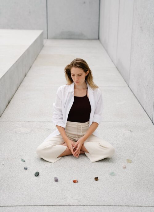 woman meditating next to mineral rocks