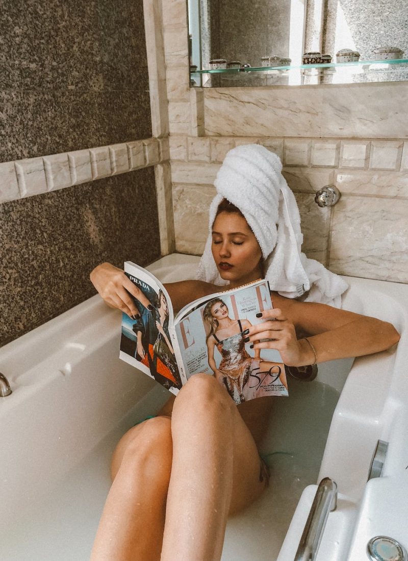woman in bathtub reading magazine