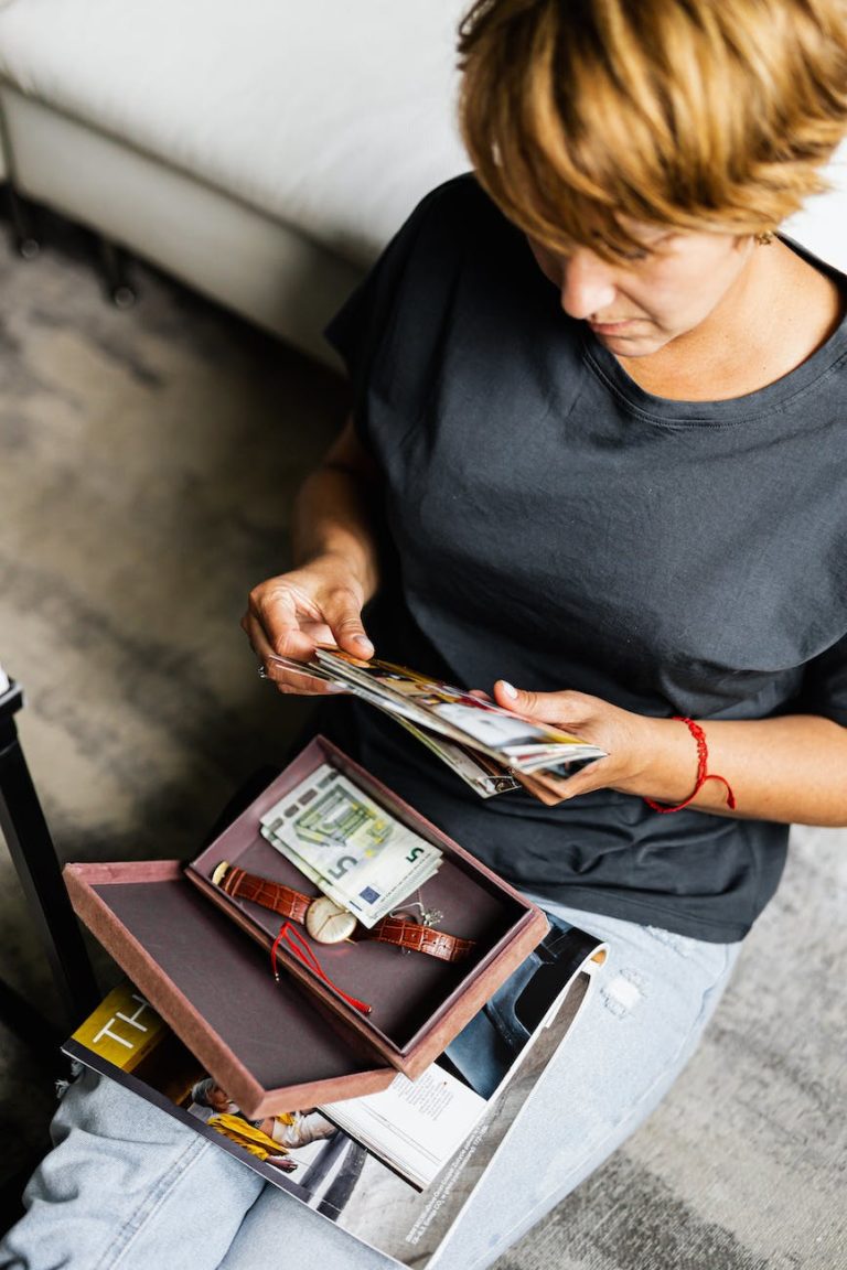 a woman sitting on a floor looking at photographs