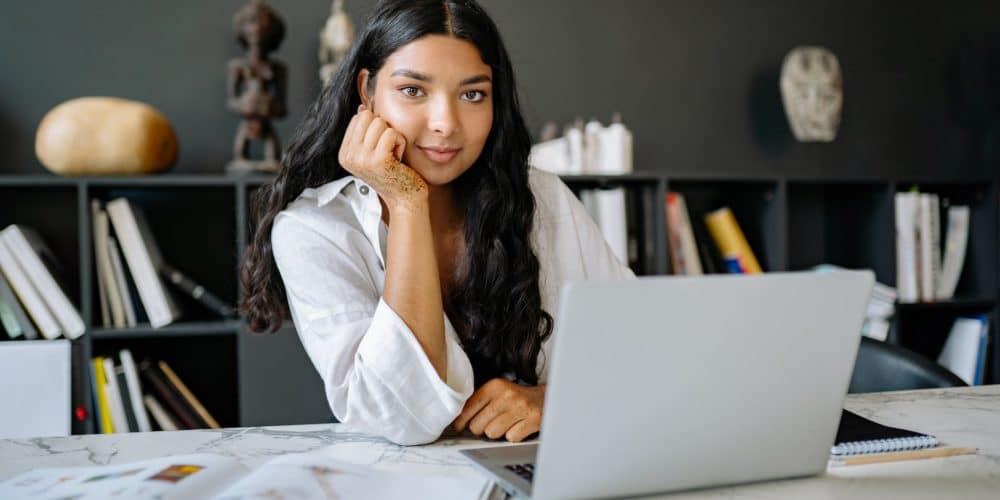 woman in white long sleeve shirt using a laptop