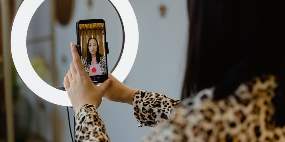 a woman using smartphone and ring light